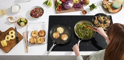 top-view-woman-cooking-on-kitchenaid-cooktop